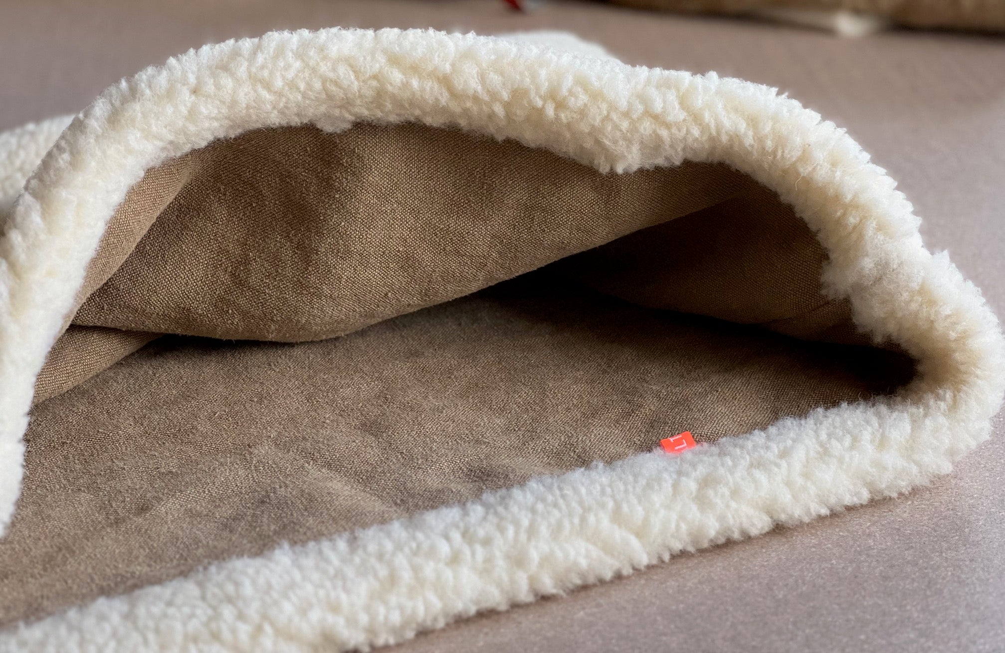 Indoor Hundehöhle aus natürlichen Materialien. Robuster Bio-Hanf und kuschelige Schafwolle für entspannten Schlaf.