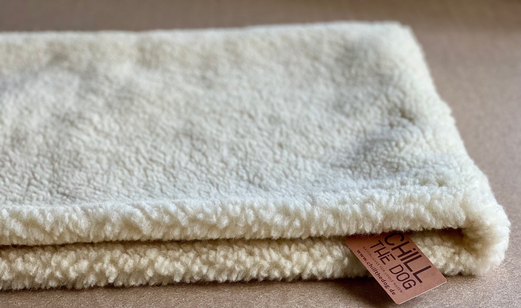 Winterseite der Hundehöhle aus Schafwolle und Bio-Hanf. Flach ausgelegt ist die Hundehöhle eine dicke Hundedecke.