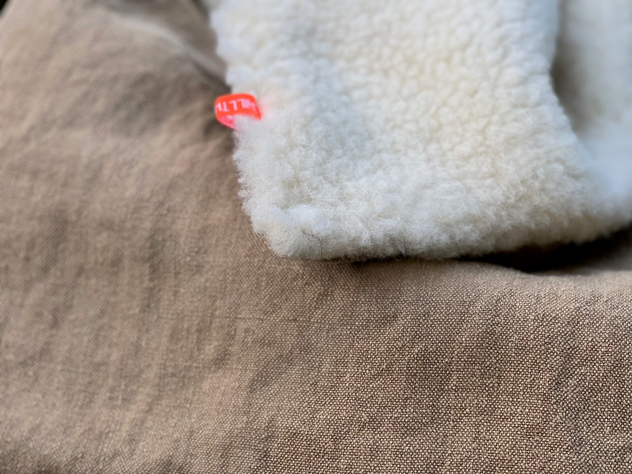 Hundedecke für unterwegs als Picknickauflage auf Waldweg, Schafwollseite sichtbar