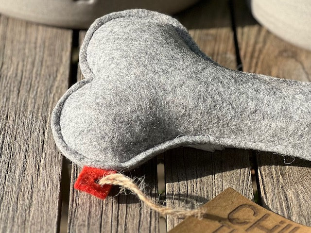 Hundeknochen Knusperwolle aus Wollfilz auf einem Holztisch